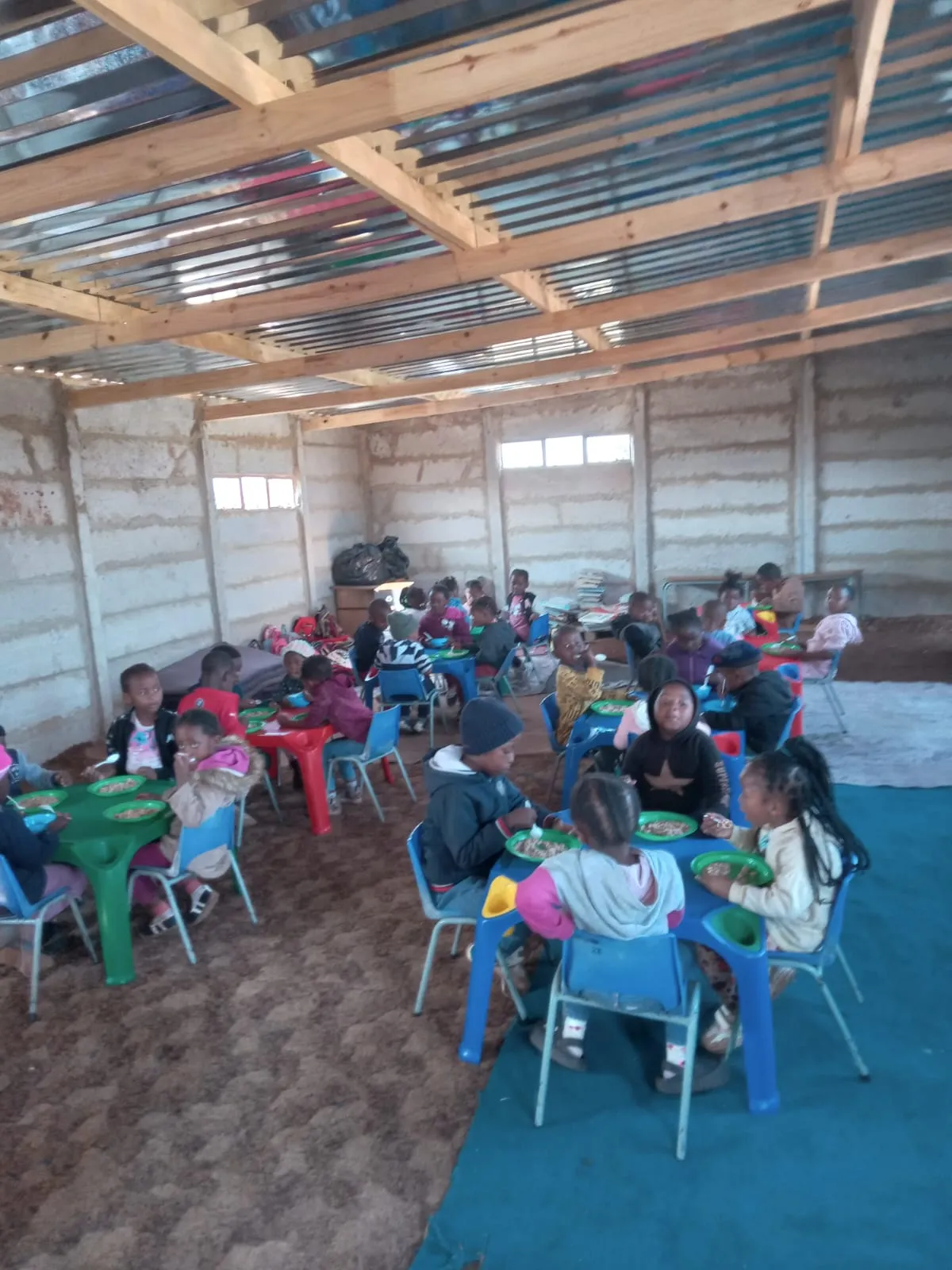 Children having a meal inside the completed classroom